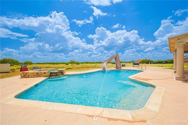 view of pool with an in ground hot tub, a water slide, and a patio