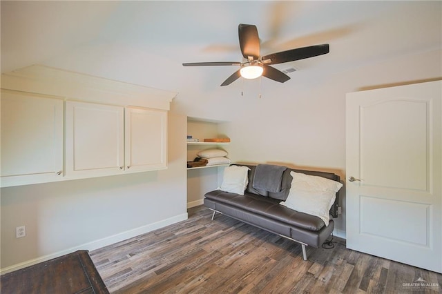 sitting room with ceiling fan and dark wood-type flooring