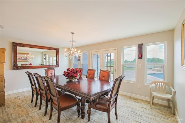 dining room with plenty of natural light, a chandelier, and light hardwood / wood-style flooring