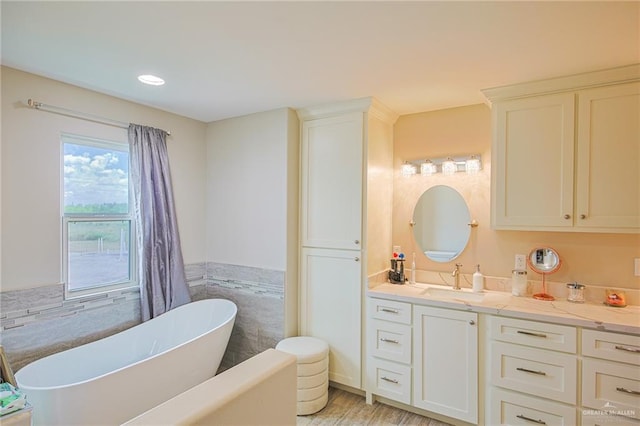 bathroom featuring a tub to relax in, vanity, and wood-type flooring