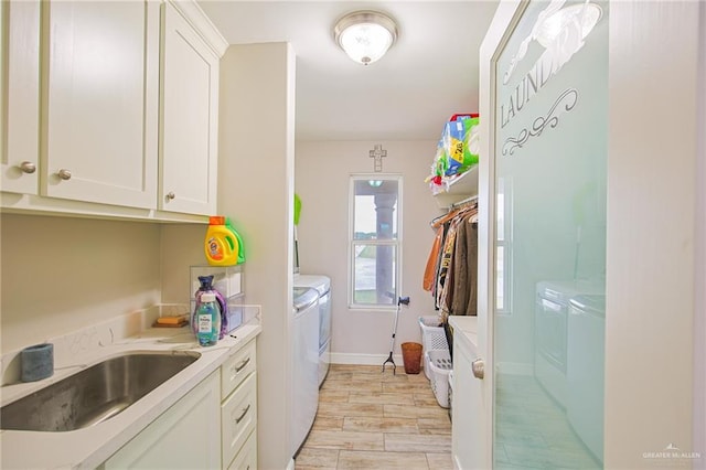 laundry room with cabinets, separate washer and dryer, light hardwood / wood-style flooring, and sink