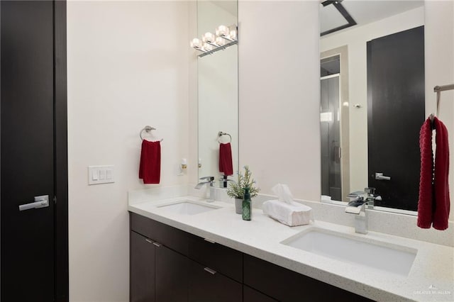 full bathroom with double vanity, a stall shower, and a sink