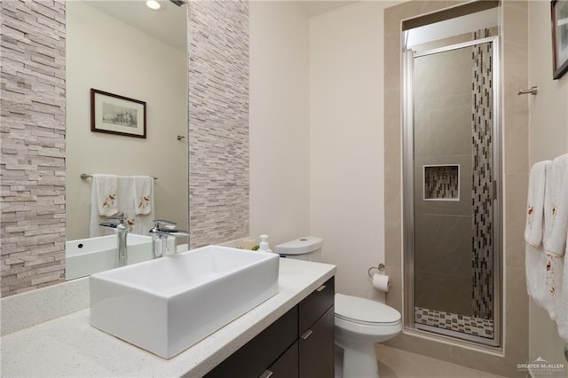 full bathroom with toilet, a shower stall, and vanity