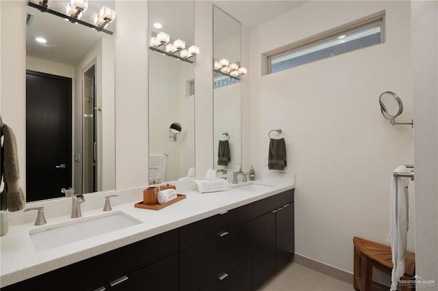 bathroom with double vanity, a sink, and baseboards