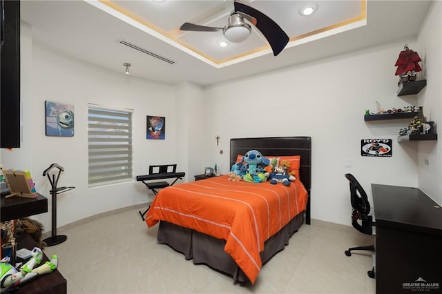 bedroom with ceiling fan, a raised ceiling, and visible vents