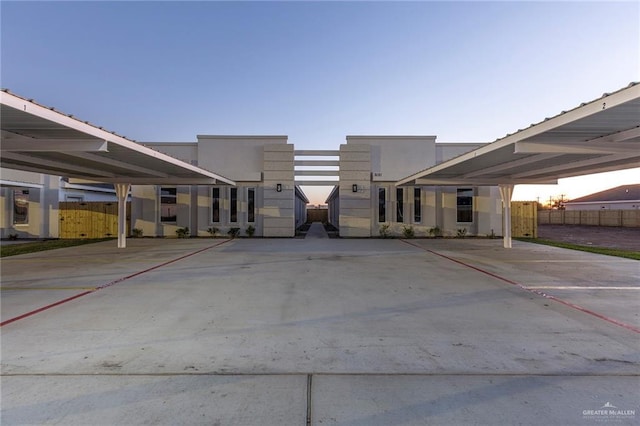 parking at dusk featuring a carport