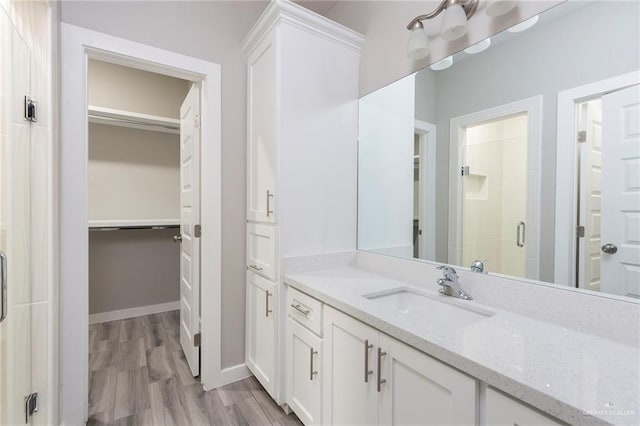 bathroom with vanity, wood-type flooring, and walk in shower