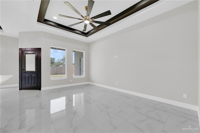 2313 Blue Sky Dr, Weslaco, TX 78599 - spare room with a ceiling fan, light marble finish floors, and a tray ceiling