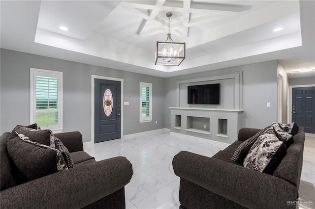 living room with a notable chandelier, a healthy amount of sunlight, a tray ceiling, and coffered ceiling