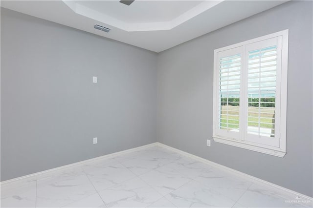 unfurnished room featuring a raised ceiling