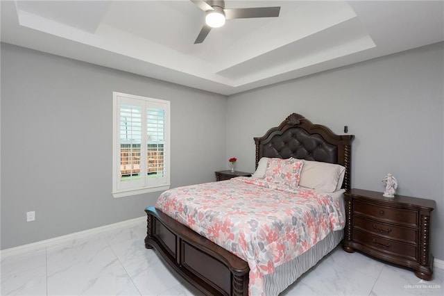 bedroom featuring a raised ceiling and ceiling fan