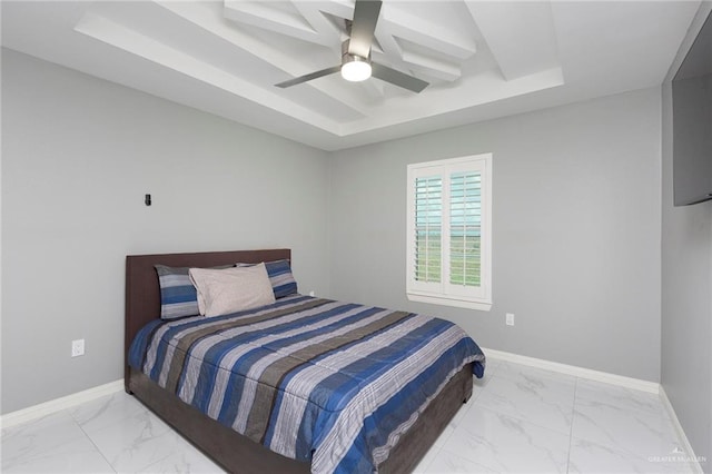 bedroom with ceiling fan and a raised ceiling