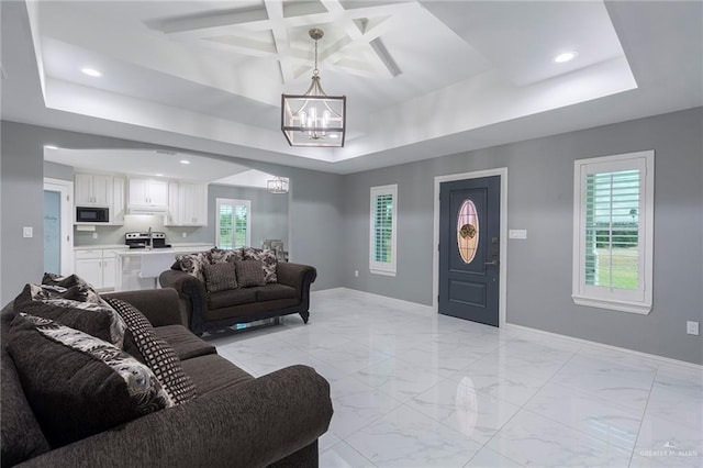 living room featuring a tray ceiling, beamed ceiling, coffered ceiling, and a notable chandelier