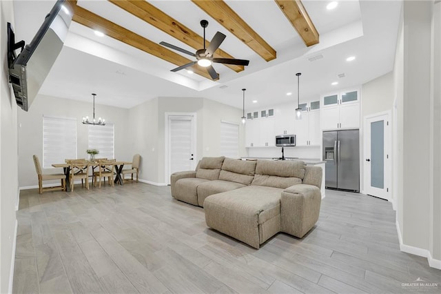 1409 E Danielle Ave E, Pharr, TX 78577 - living room with baseboards, light wood-style flooring, a raised ceiling, and ceiling fan with notable chandelier