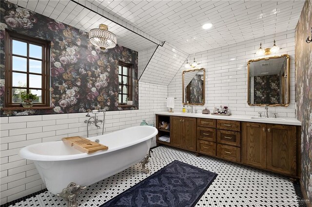 707 N 15th St, Mcallen, TX 78501 - bathroom featuring tile walls, double vanity, a freestanding tub, wainscoting, and wallpapered walls