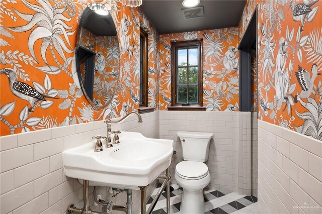 707 N 15th St, Mcallen, TX 78501 - bathroom featuring wallpapered walls, wainscoting, tile walls, and tile patterned flooring