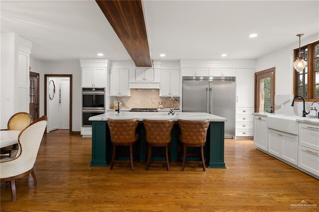 707 N 15th St, Mcallen, TX 78501 - kitchen with appliances with stainless steel finishes, decorative backsplash, recessed lighting, white cabinetry, and wood finished floors