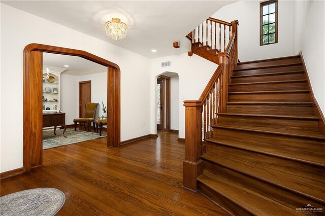707 N 15th St, Mcallen, TX 78501 - foyer entrance featuring arched walkways, stairway, dark wood-type flooring, and a chandelier