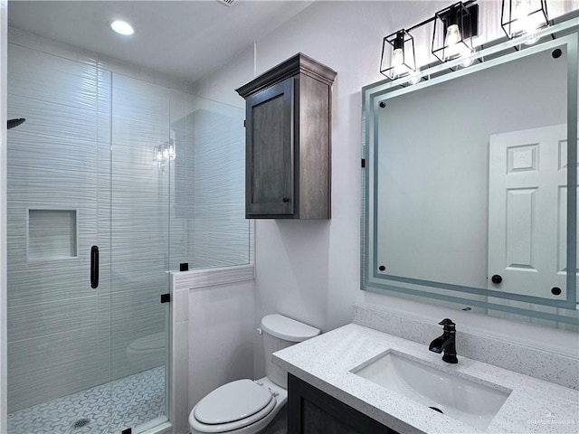 bathroom featuring vanity, toilet, recessed lighting, and a stall shower