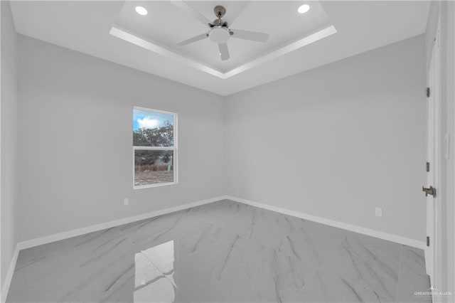 spare room featuring ceiling fan and a tray ceiling