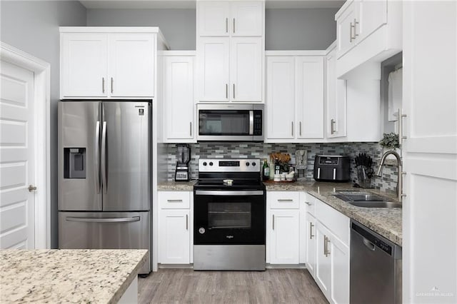 1012 Cooper Ln, San Juan, TX 78589 - kitchen featuring appliances with stainless steel finishes, a sink, white cabinets, and tasteful backsplash