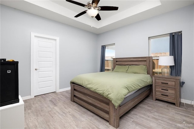 1012 Cooper Ln, San Juan, TX 78589 - bedroom with wood finished floors, baseboards, a raised ceiling, and a ceiling fan