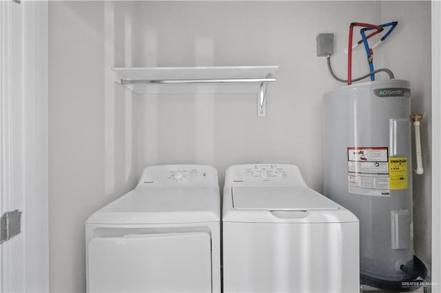 washroom featuring laundry area, electric water heater, and separate washer and dryer