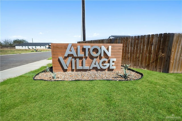 community / neighborhood sign featuring a lawn and fence