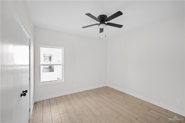 spare room with ceiling fan, light wood-style flooring, and baseboards