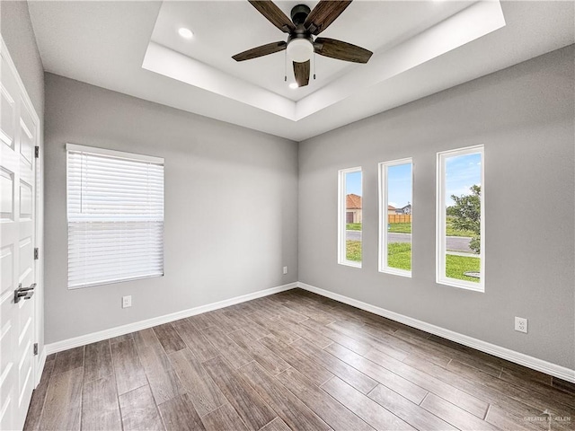 2200 Zinnia St, Weslaco, TX 78599 - spare room featuring a tray ceiling, dark wood-style flooring, a ceiling fan, and recessed lighting