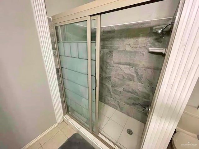 bathroom with tile patterned floors, toilet, and walk in shower