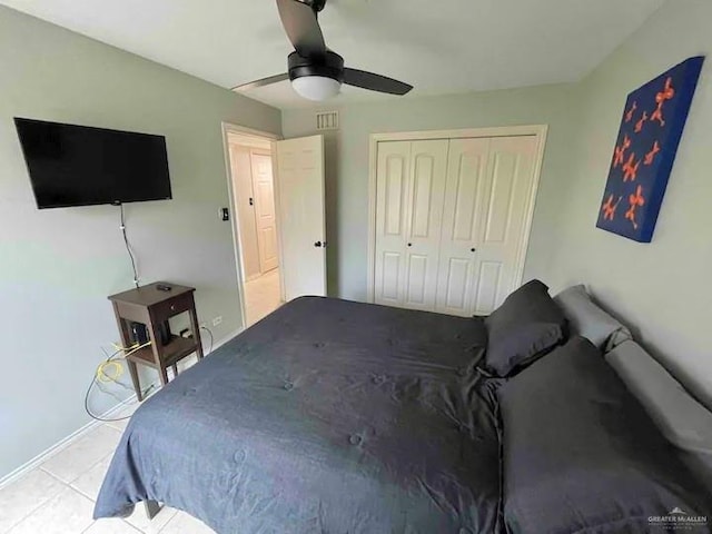 tiled bedroom featuring ceiling fan and a closet