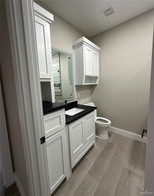 bathroom featuring vanity, toilet, and wood-type flooring