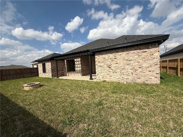 rear view of house featuring a lawn, a patio area, and a fire pit