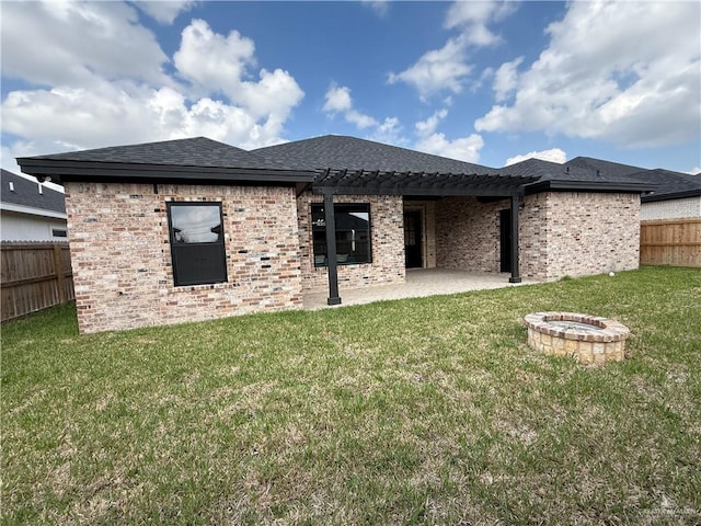 back of property featuring a fire pit, a lawn, and a patio