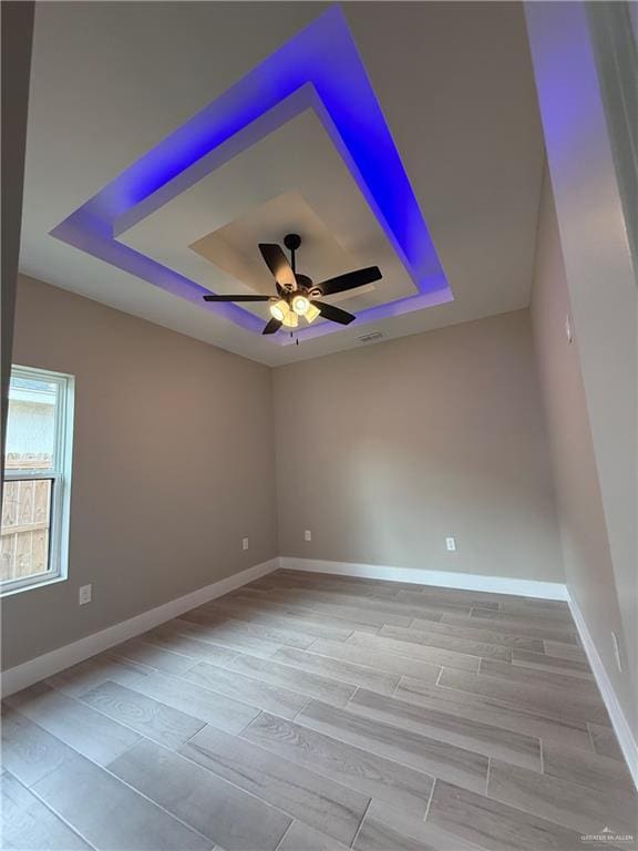 unfurnished room featuring ceiling fan and a tray ceiling