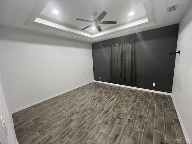 unfurnished room with dark hardwood / wood-style floors, a raised ceiling, and ceiling fan