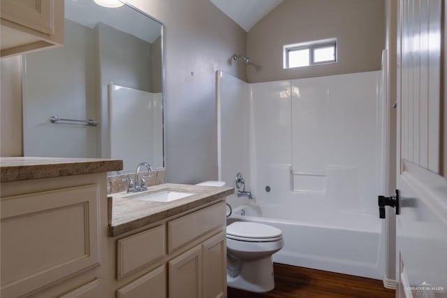 full bathroom featuring vanity, bathtub / shower combination, vaulted ceiling, toilet, and wood-type flooring