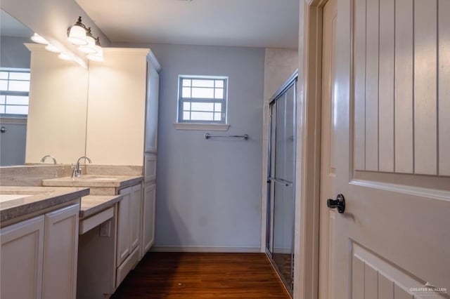 bathroom with hardwood / wood-style flooring, vanity, a healthy amount of sunlight, and a shower with door