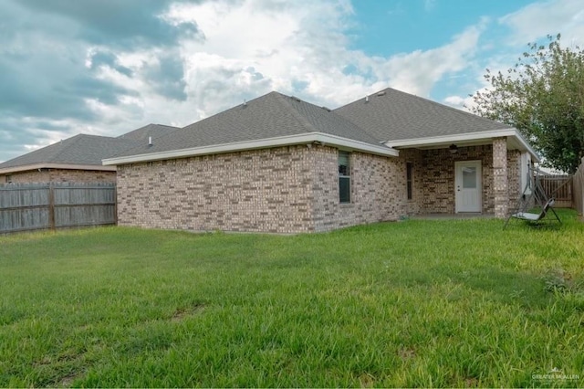 back of property featuring a lawn