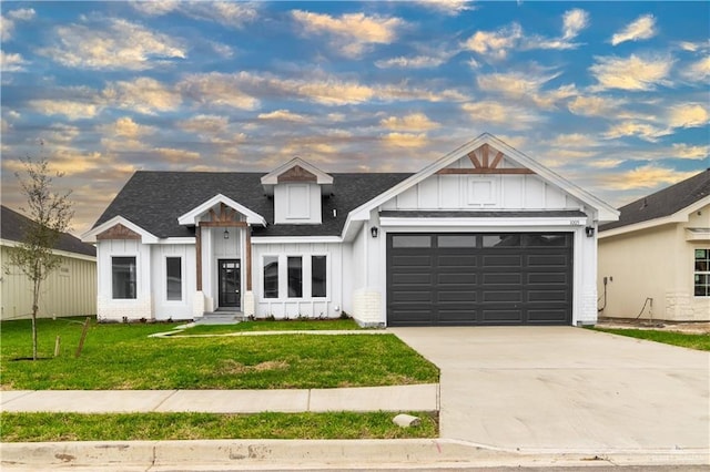 modern farmhouse style home featuring roof with shingles, a front lawn, concrete driveway, a garage, and board and batten siding