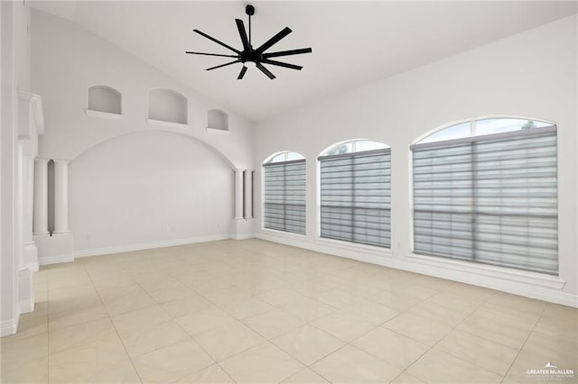 tiled empty room featuring ceiling fan and high vaulted ceiling