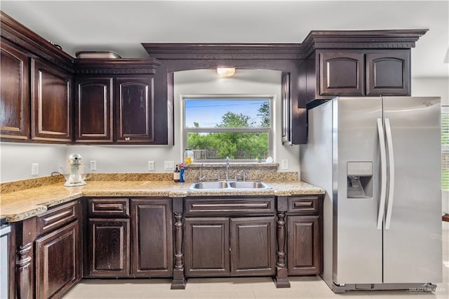 kitchen with light tile patterned floors, a sink, stainless steel refrigerator with ice dispenser, and dark brown cabinetry