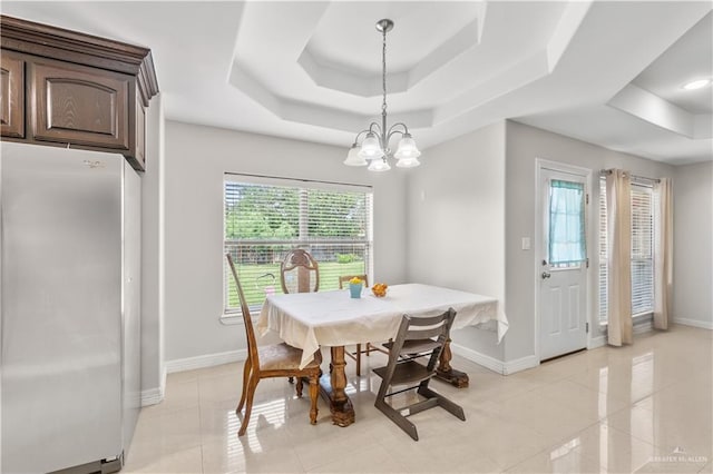 dining room with baseboards, a tray ceiling, a chandelier, and light tile patterned floors