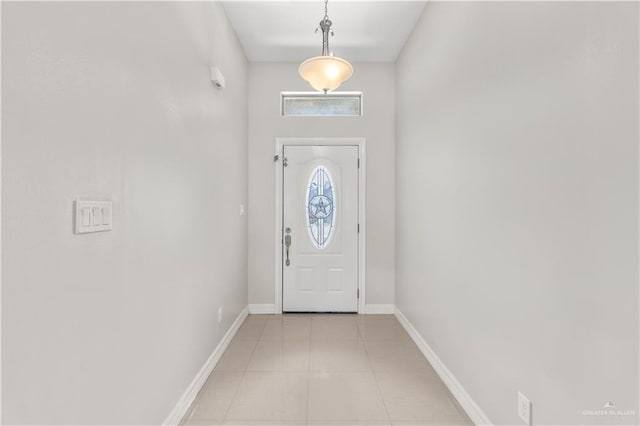 doorway to outside with baseboards and light tile patterned flooring