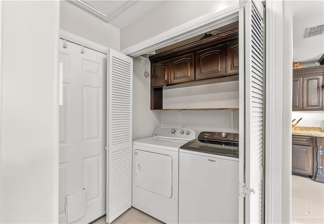 laundry room featuring visible vents, light tile patterned flooring, cabinet space, and washer and clothes dryer