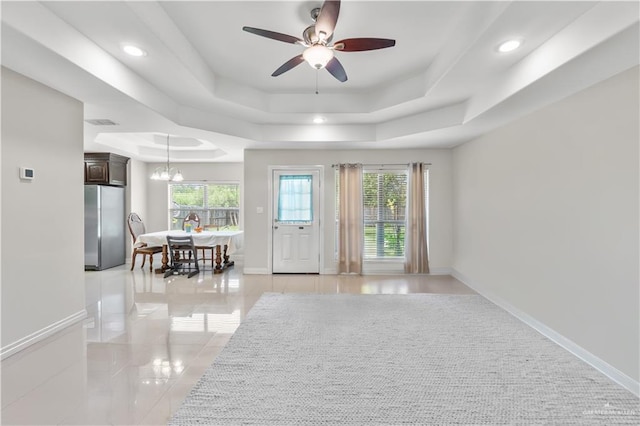 interior space featuring recessed lighting, a wealth of natural light, a raised ceiling, and ceiling fan with notable chandelier