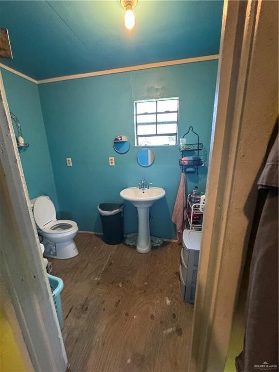 half bathroom featuring toilet and wood finished floors
