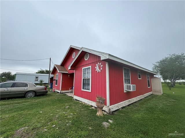 view of side of property featuring a lawn and cooling unit