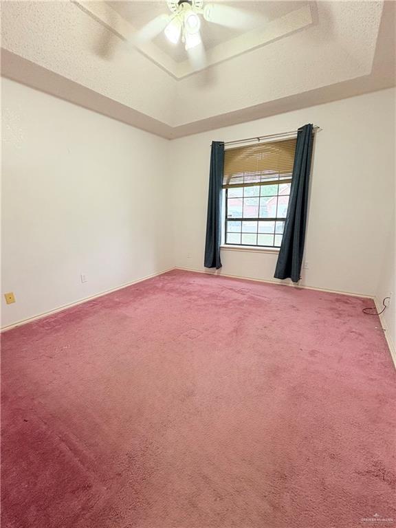 2218 Lawndale Rd, Mission, TX 78572 - empty room featuring baseboards, a ceiling fan, a tray ceiling, and carpet flooring
